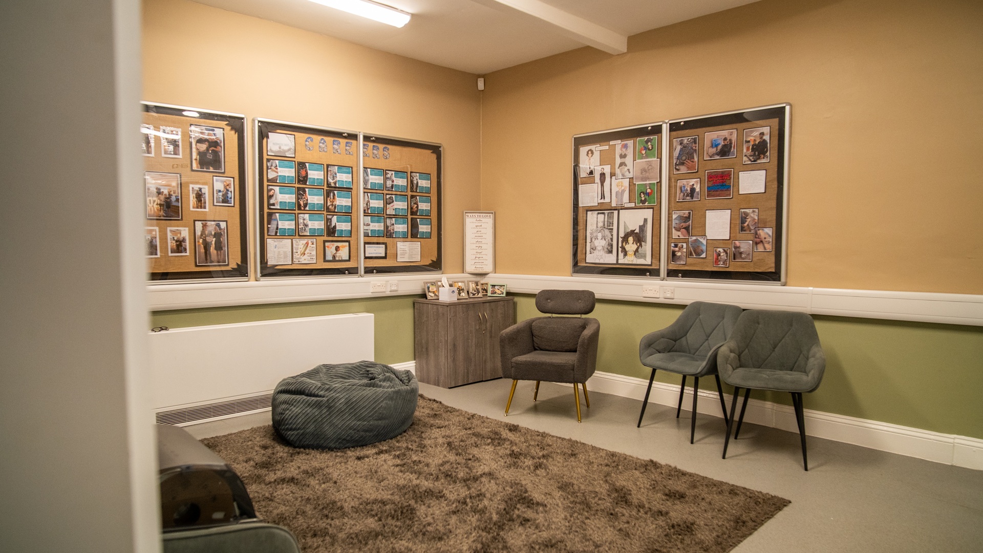 Relaxed lounge space with informal seating, careers information on noticeboards, rug on the floor