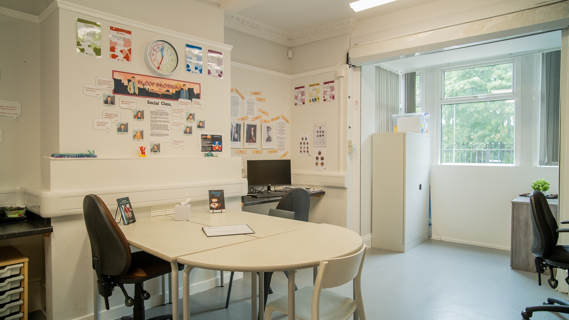 Teaching space with posters on the wall about blood brothers and english language
